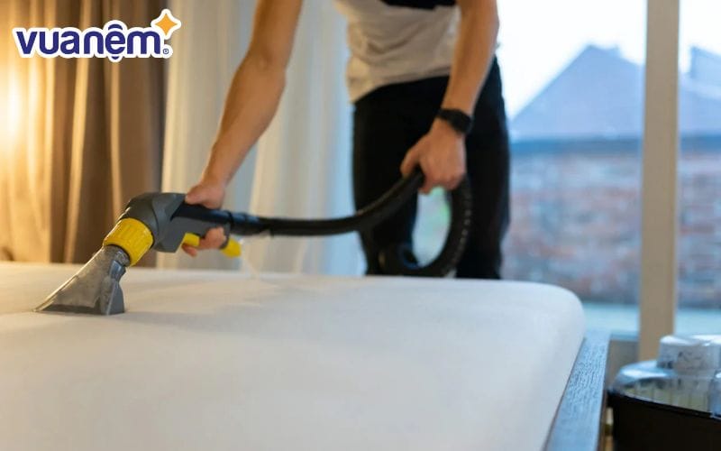 Hút bụi trước khi giặt là một bước quan trọng trong quá trình vệ sinh topper tại nhà.