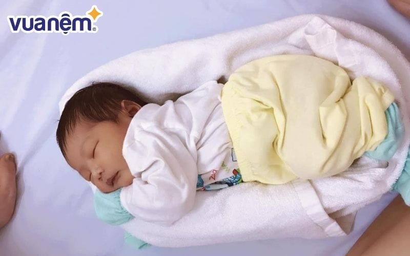 Quấn khăn quanh cơ thể tạo thành ổ cho bé nằm nghiêng 