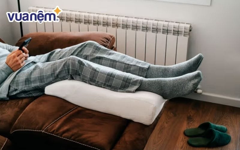 Dùng gối gác chân giúp giảm áp lực lên phần thân dưới