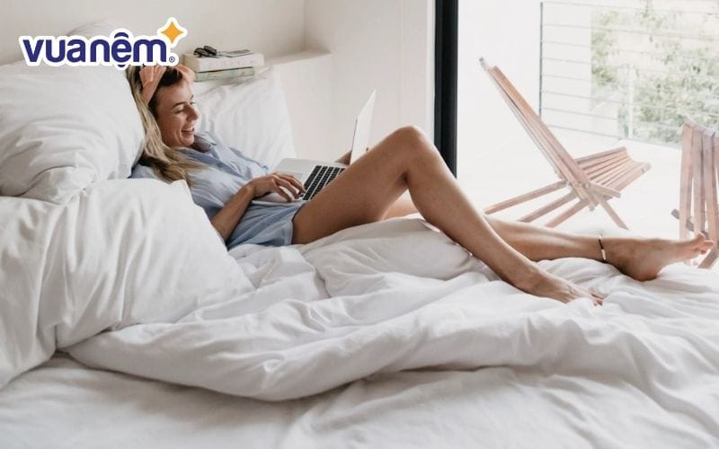 Đặt một chiếc gối sau đầu khi ngồi trên giường để hỗ trợ nâng đỡ cổ và đầu