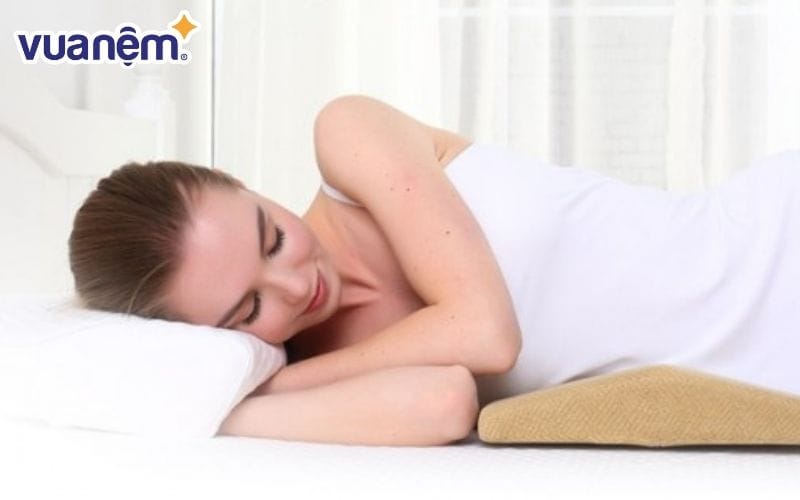 Kê gối dưới lưng khi ngủ hỗ trợ định hình cột sống